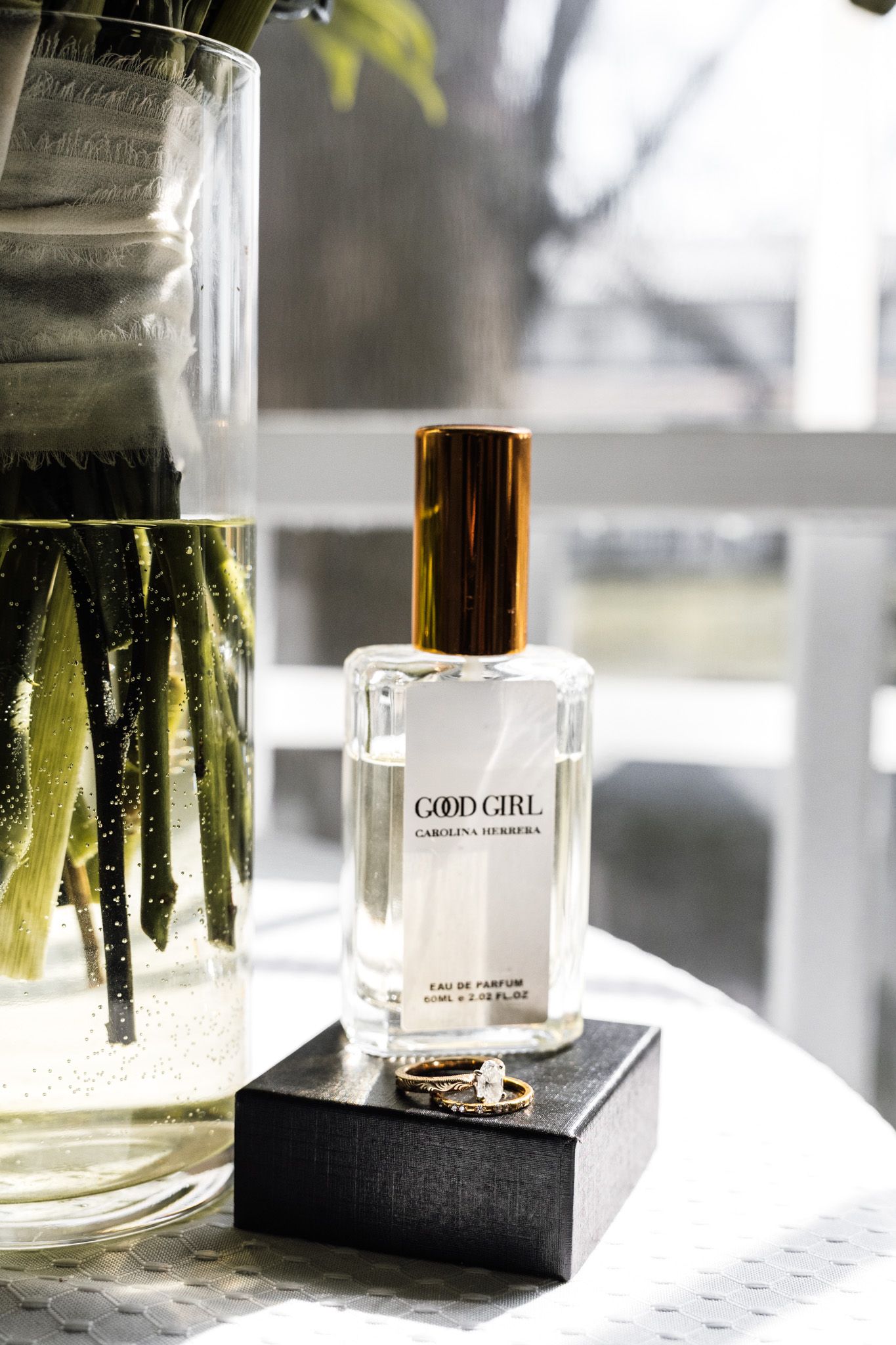 Perfume bottle of Good Girl fragrance displayed on table with soft natural lighting.