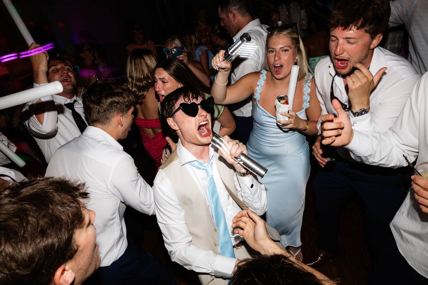 Guests dancing energetically at a lively wedding reception party on the dance floor.