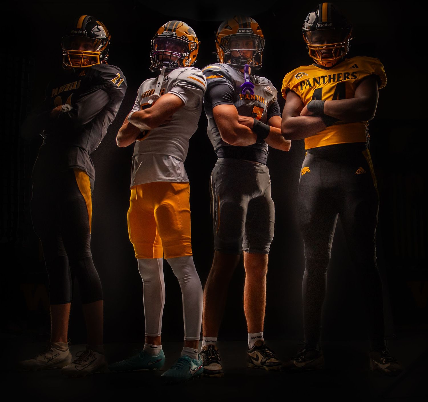 Four Panthers football players pose in gold and white uniforms against a dark background.