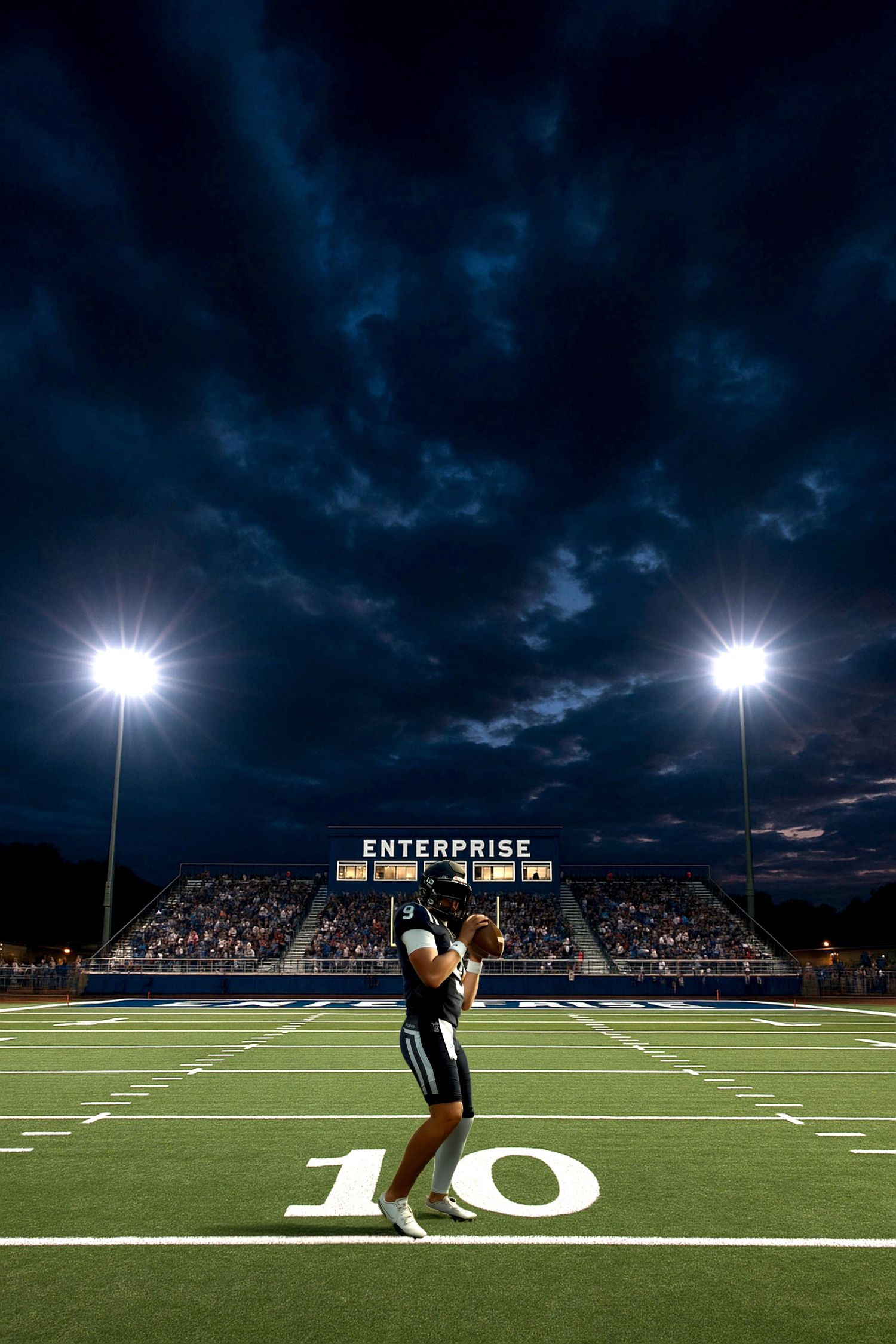 Football field at night with stadium lights illuminating the turf and stands.