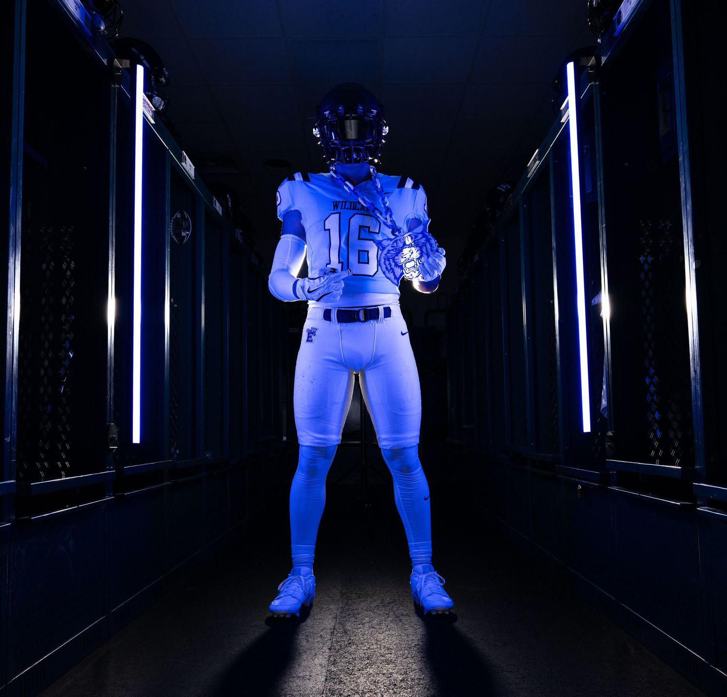 Football player in blue uniform number 16 poses in dramatic blue-lit tunnel.
