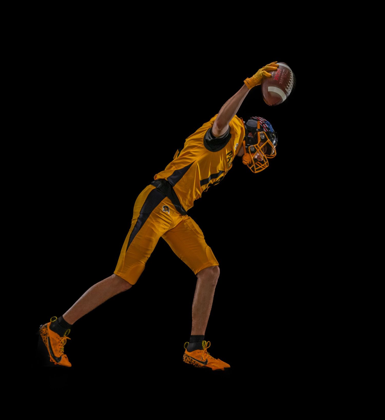 Volleyball player in yellow uniform diving to save the ball during intense match action against dark background.