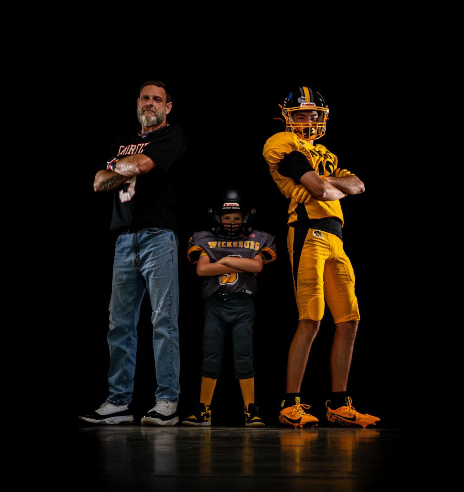 Low angle view of performers in casual attire posing against dark background with dramatic lighting.