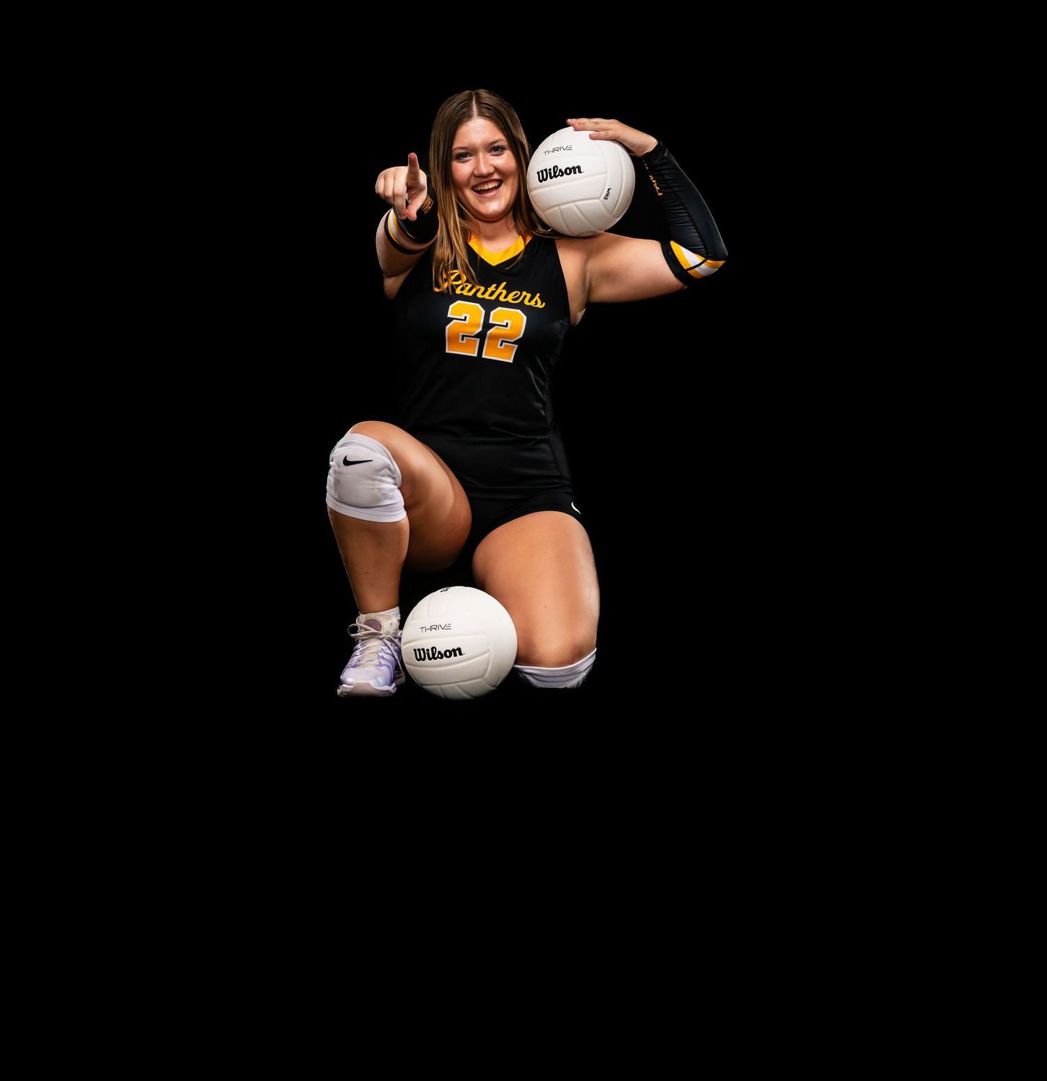 Athletes pose with Wilson volleyballs in black uniforms against dark background.