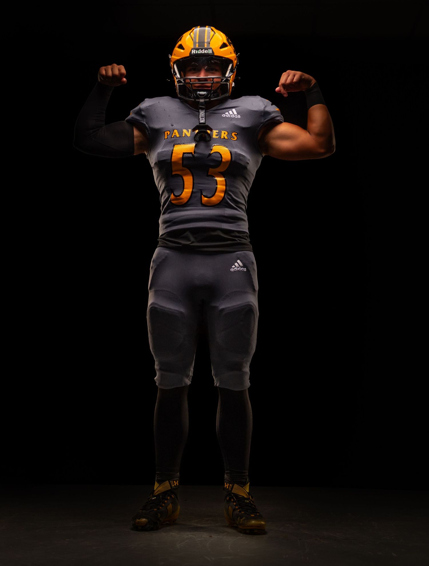 Football player wearing gray Adidas Panthers #53 uniform and gold helmet poses flexing muscles against dark background.