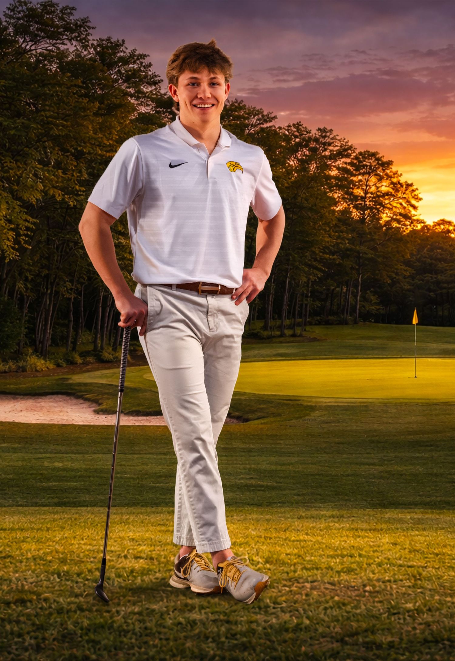 Golfer poses on course during golden sunset with golf club.