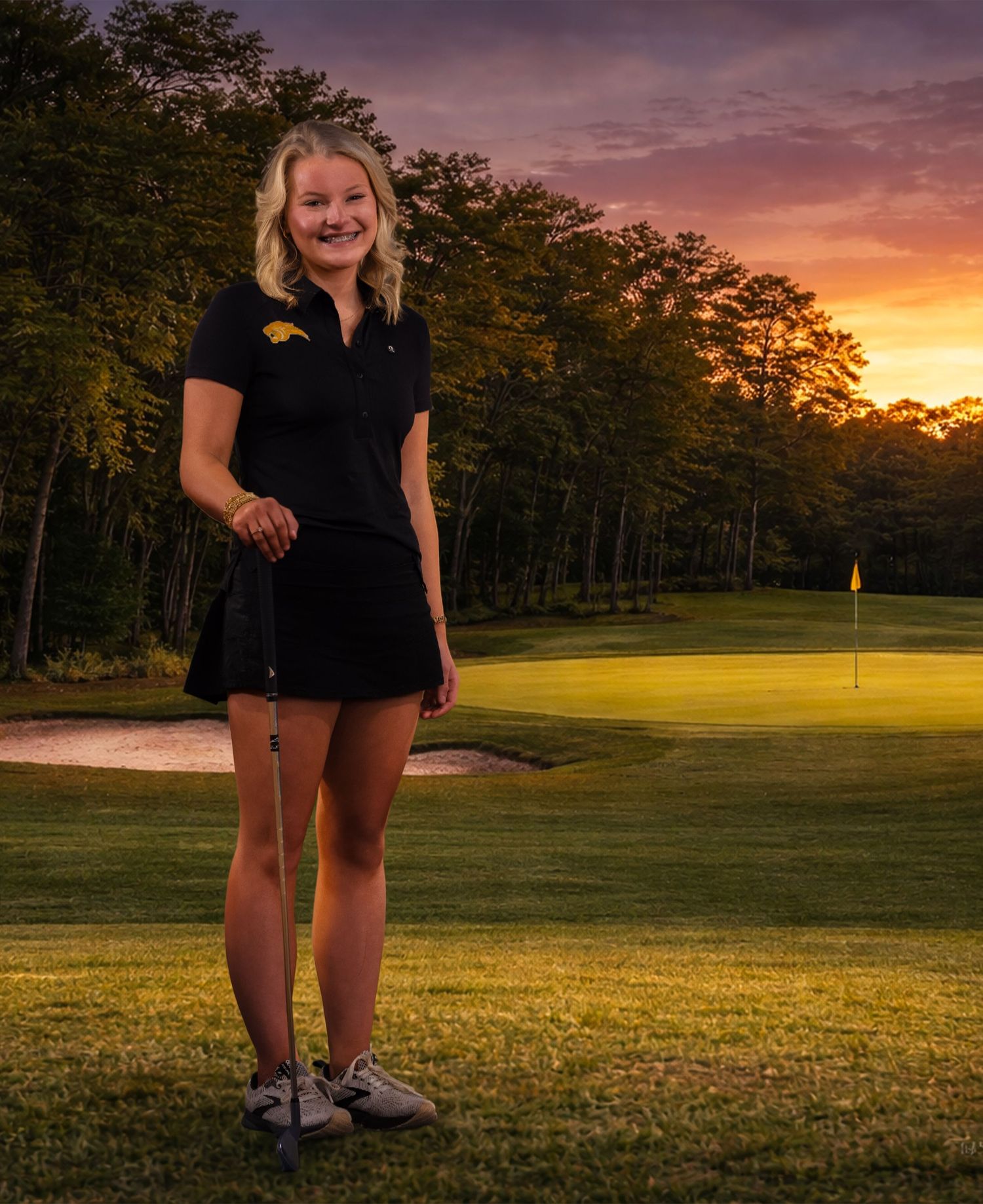 Golfer stands on lush green course during vibrant sunset with golf flag visible in distance.