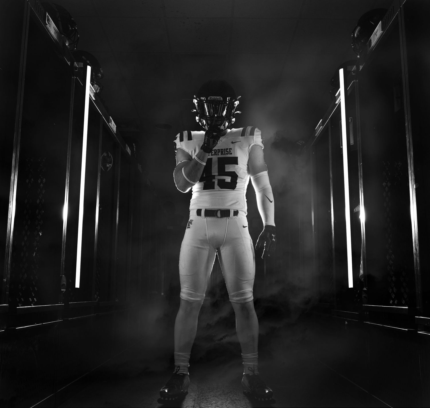 Football player wearing number 45 jersey stands in dramatic tunnel lighting.