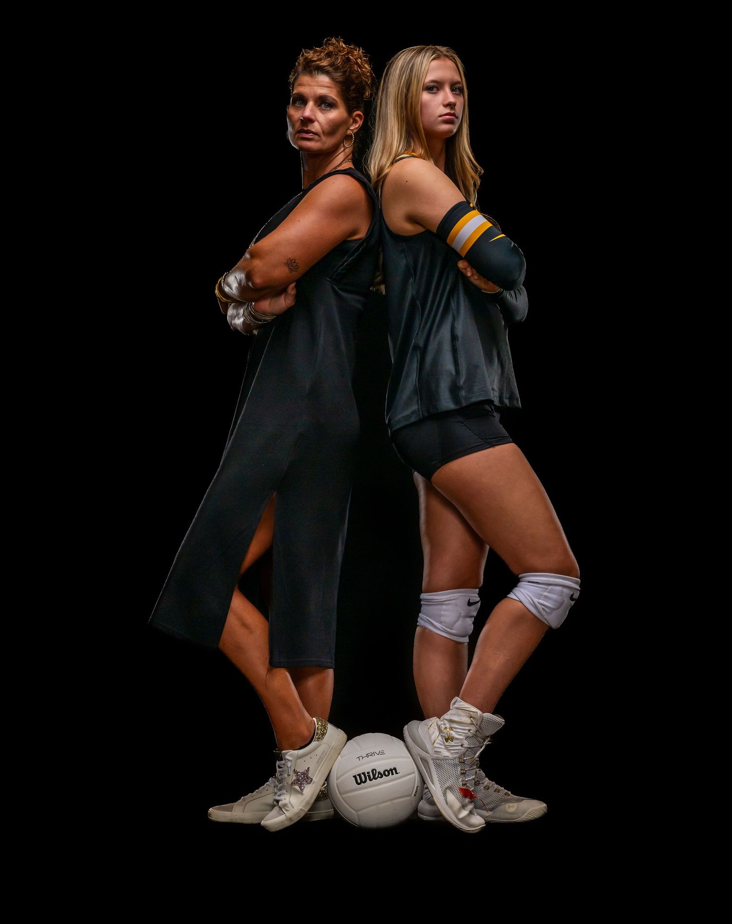Athletes in black uniforms display volleyball defensive stances against dark background.