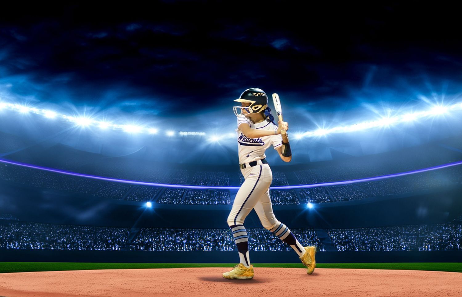 Female baseball player in white uniform swinging bat under bright stadium lights at night.