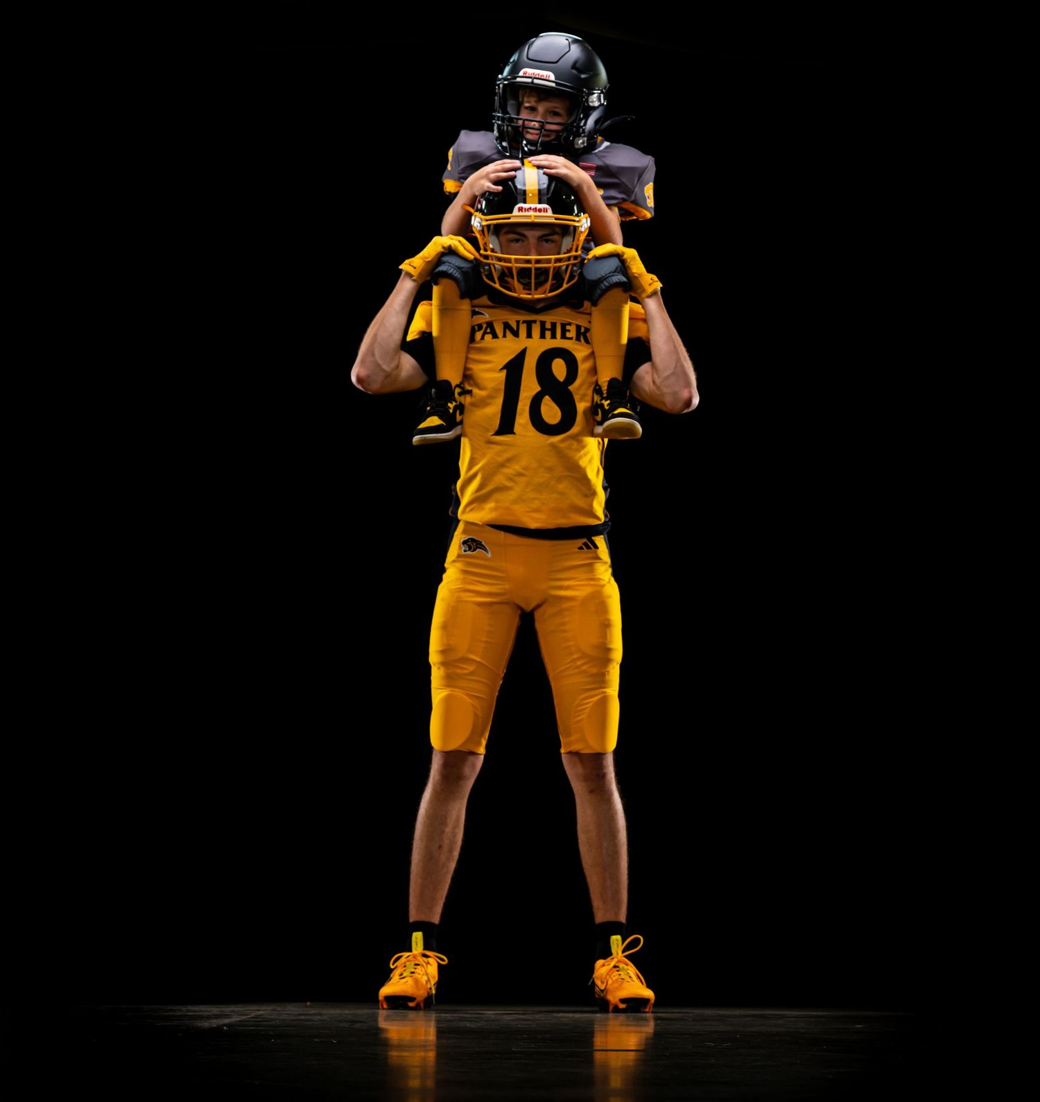 Football player in yellow uniform demonstrating catching stance sequence on dark background.
