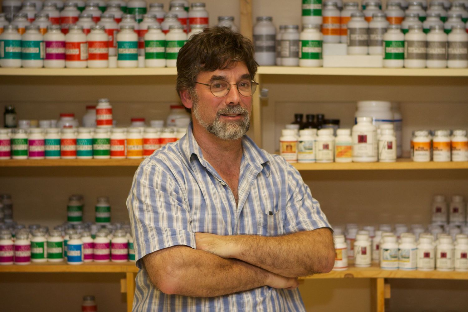 Interior view of a pharmacy shelving system stocked with various medication bottles.