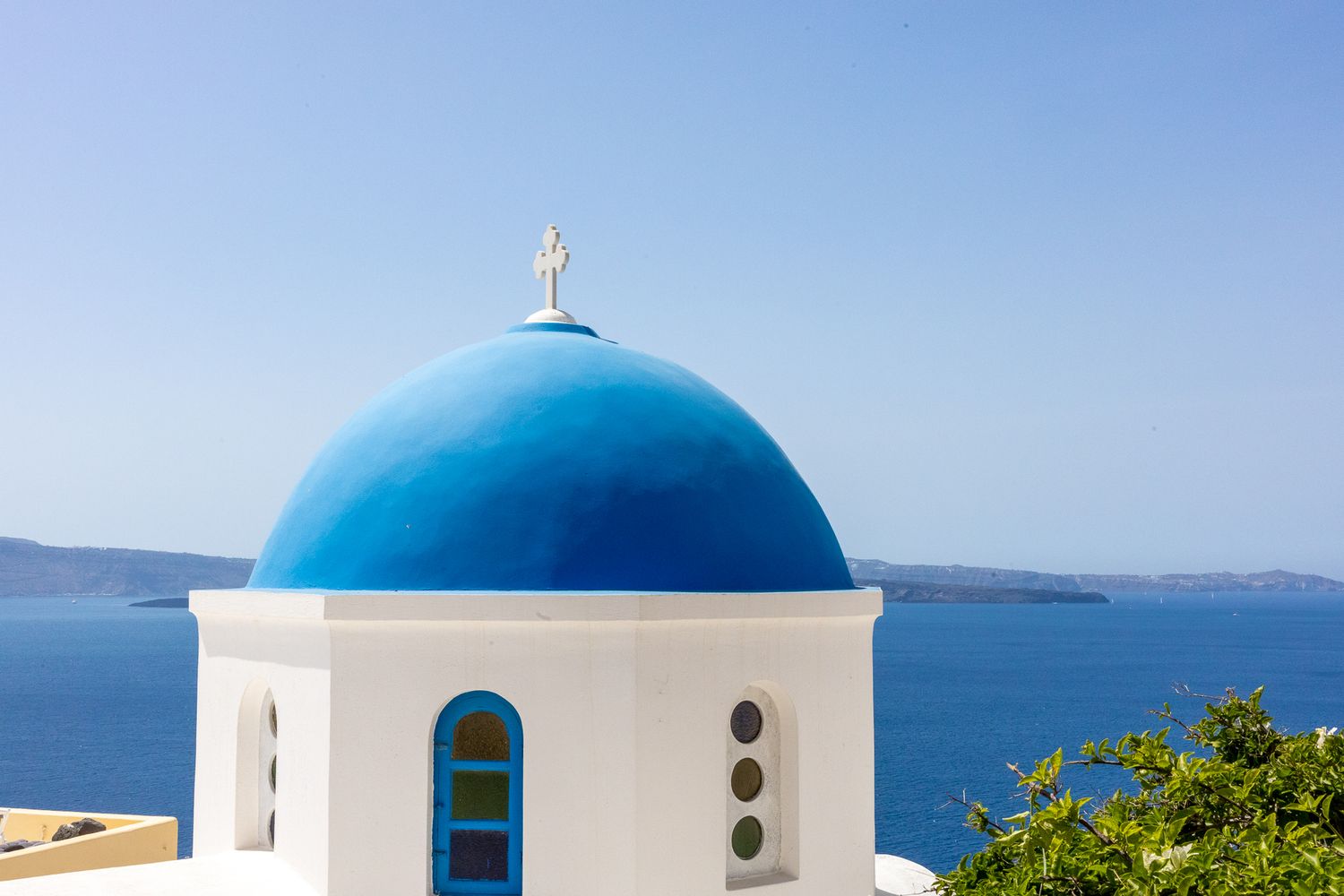 Iconic blue-domed Greek Orthodox church overlooking the Mediterranean Sea in Santorini.