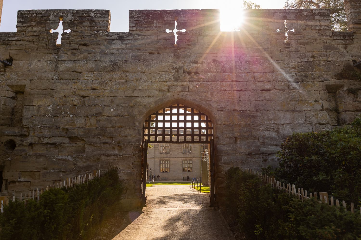 Ancient stone castle walls with sunlight streaming through openings and arched windows.