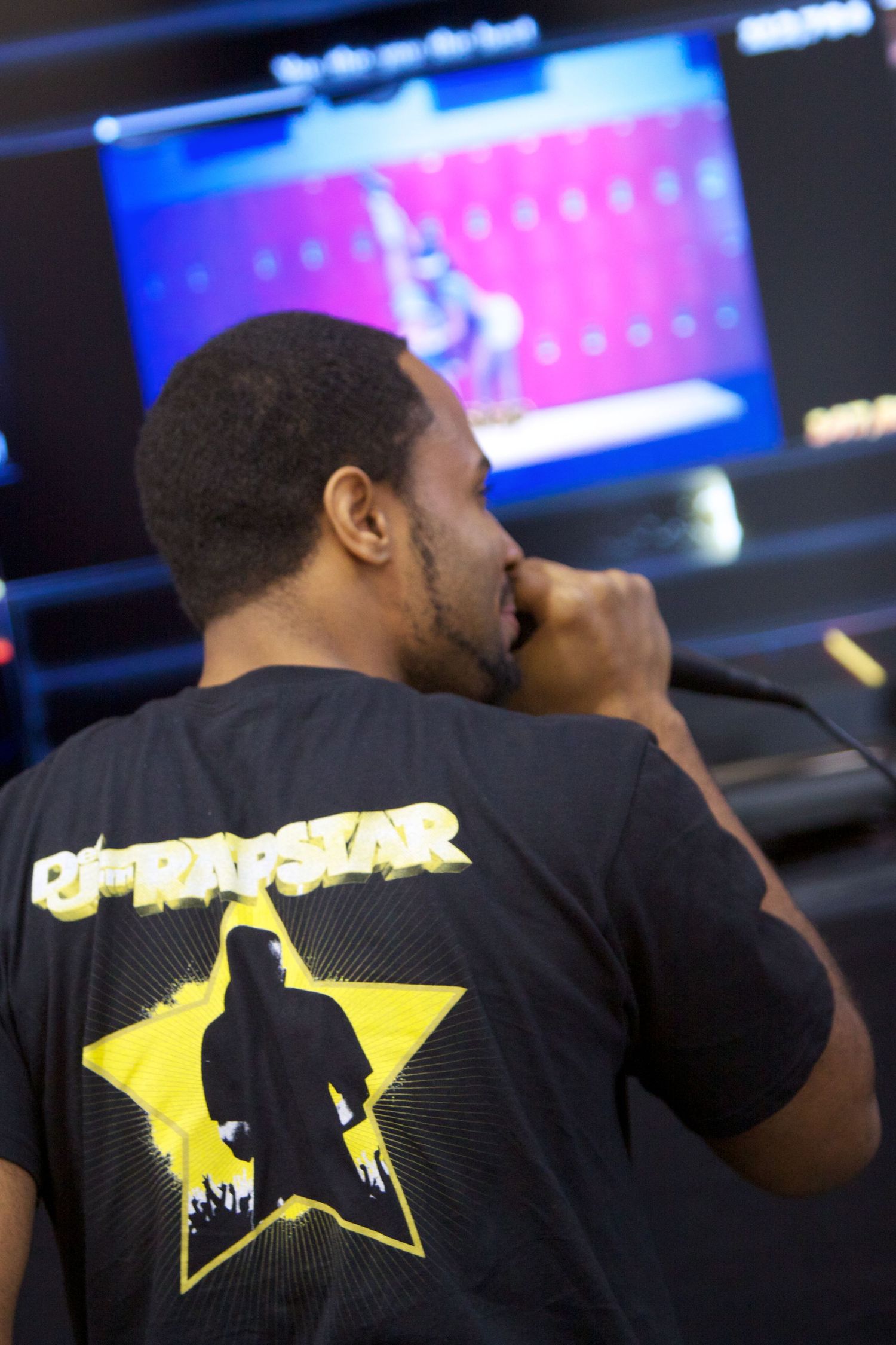 T-shirt design featuring yellow rockstar silhouette against dark background.