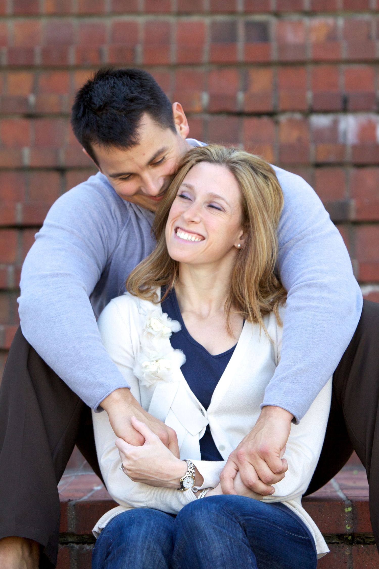 Couple sharing tender moment while sitting on brick steps.