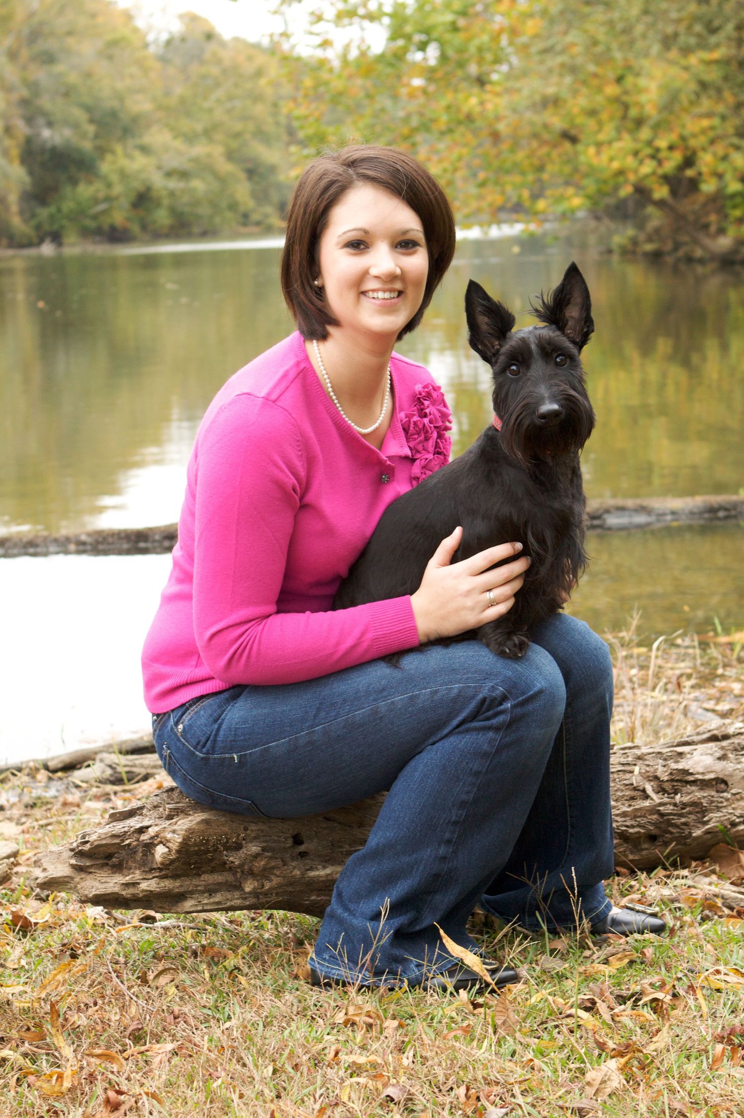 Autumn portrait with black scottie dog by lakeside.