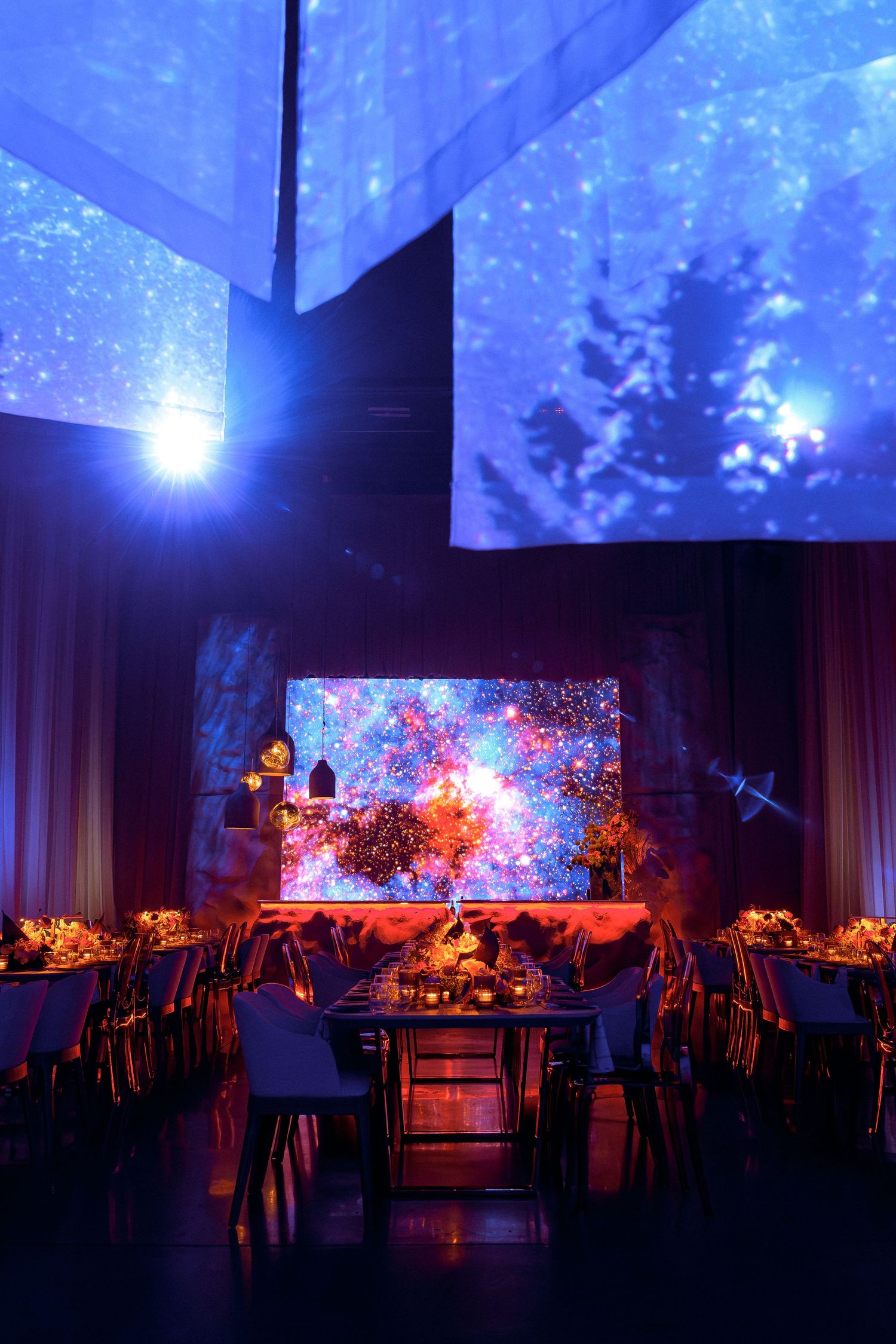 Event space with dramatic blue lighting and projected celestial patterns on the ceiling.