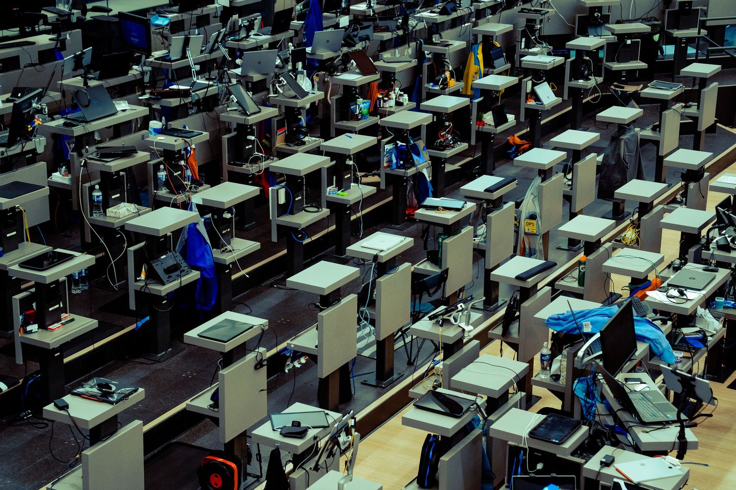 Rows of identical computer workstations in a large office space.