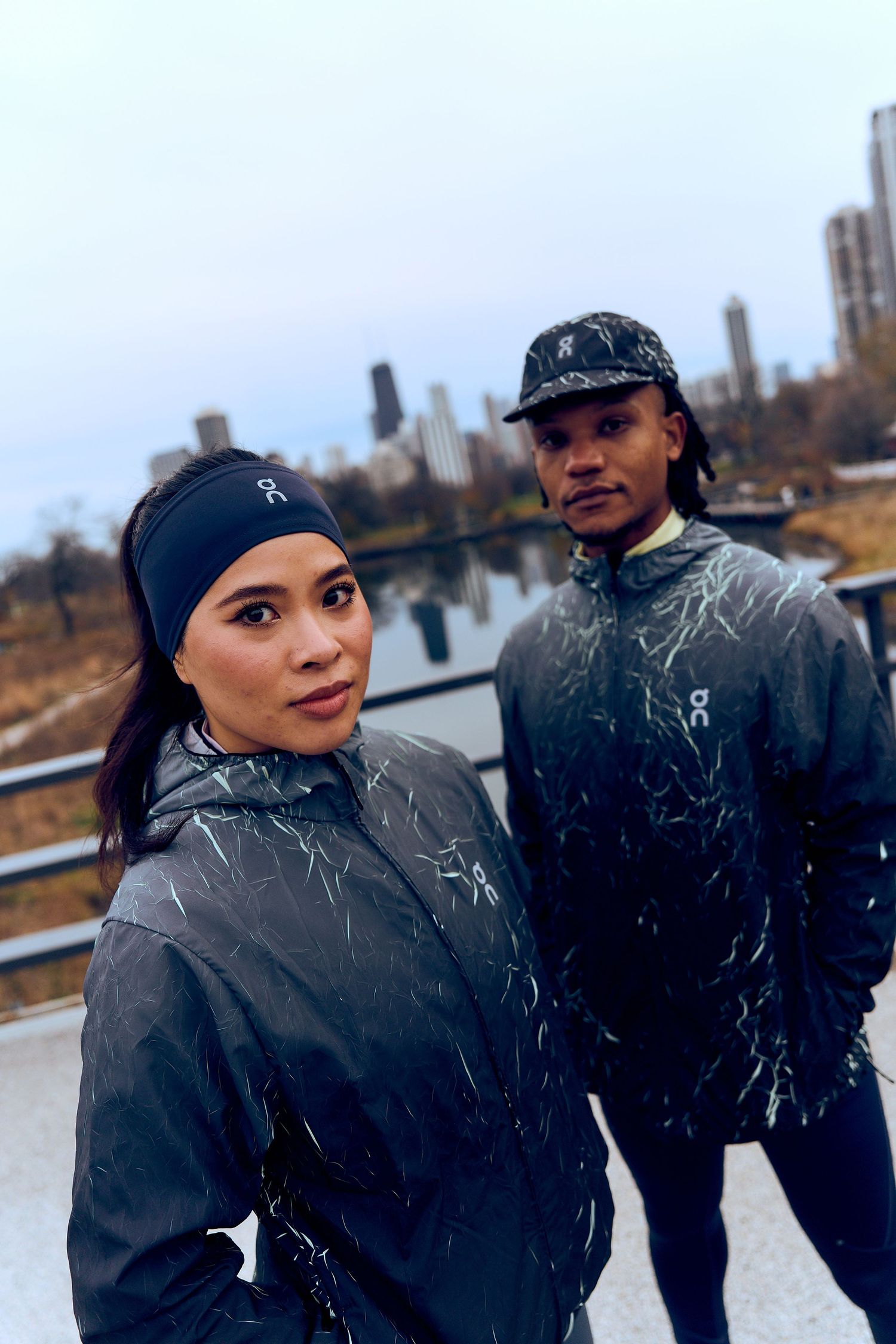 Outdoor fashion photography session showing reflective athletic wear against an urban backdrop.