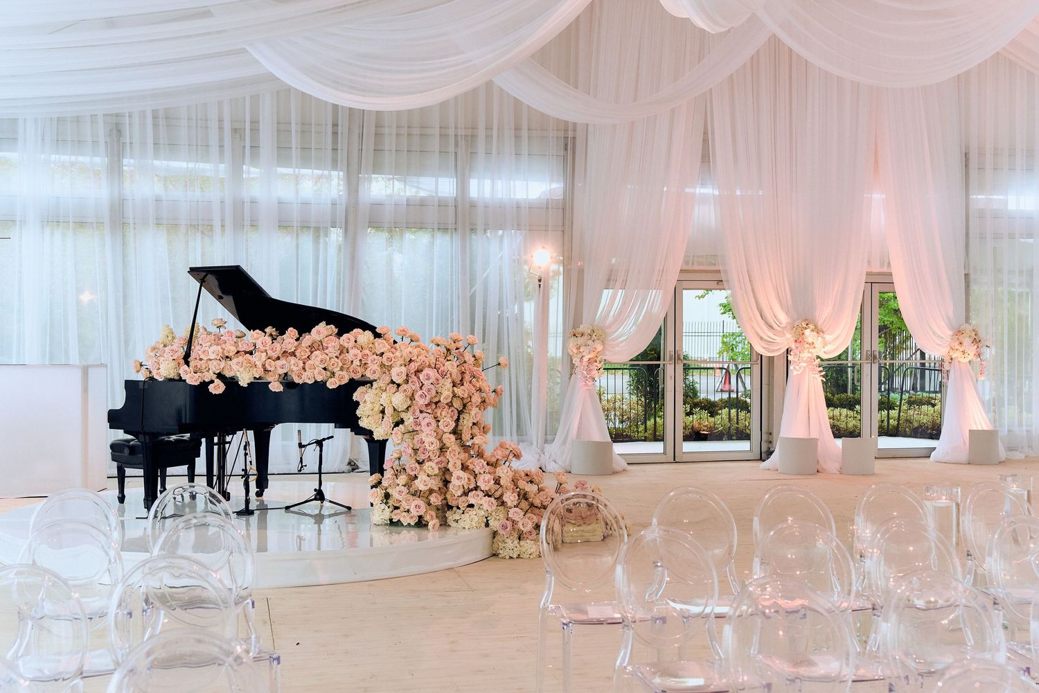 Elegant white wedding venue interior with draped fabric and grand piano visible.