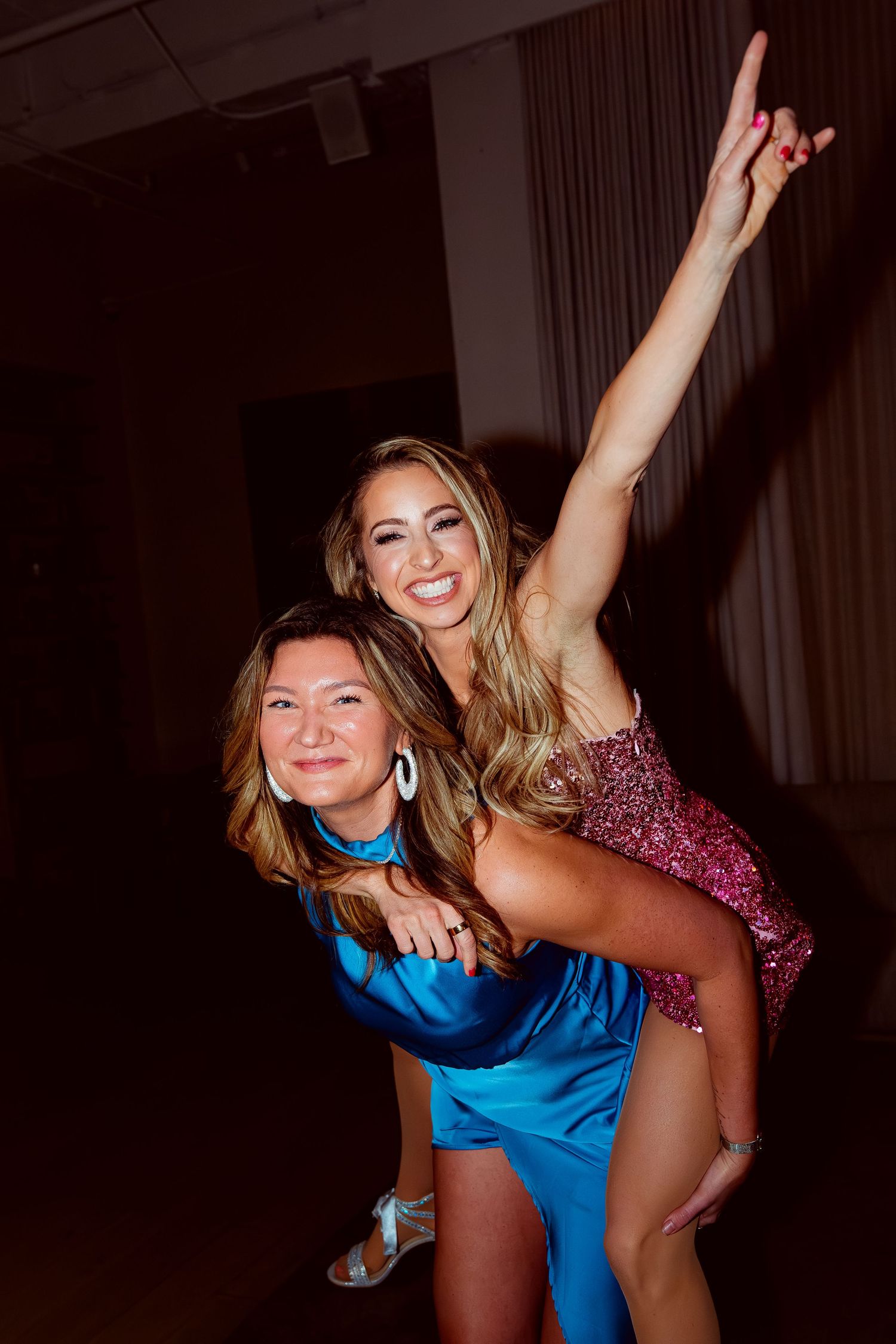 Celebratory moment at a party with two people posing playfully.