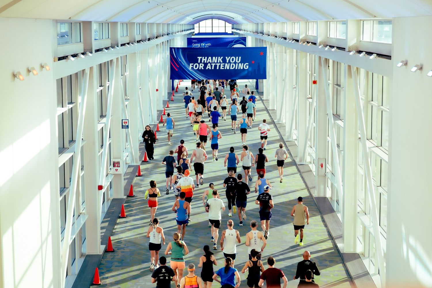 Long white corridor filled with runners during indoor marathon event.