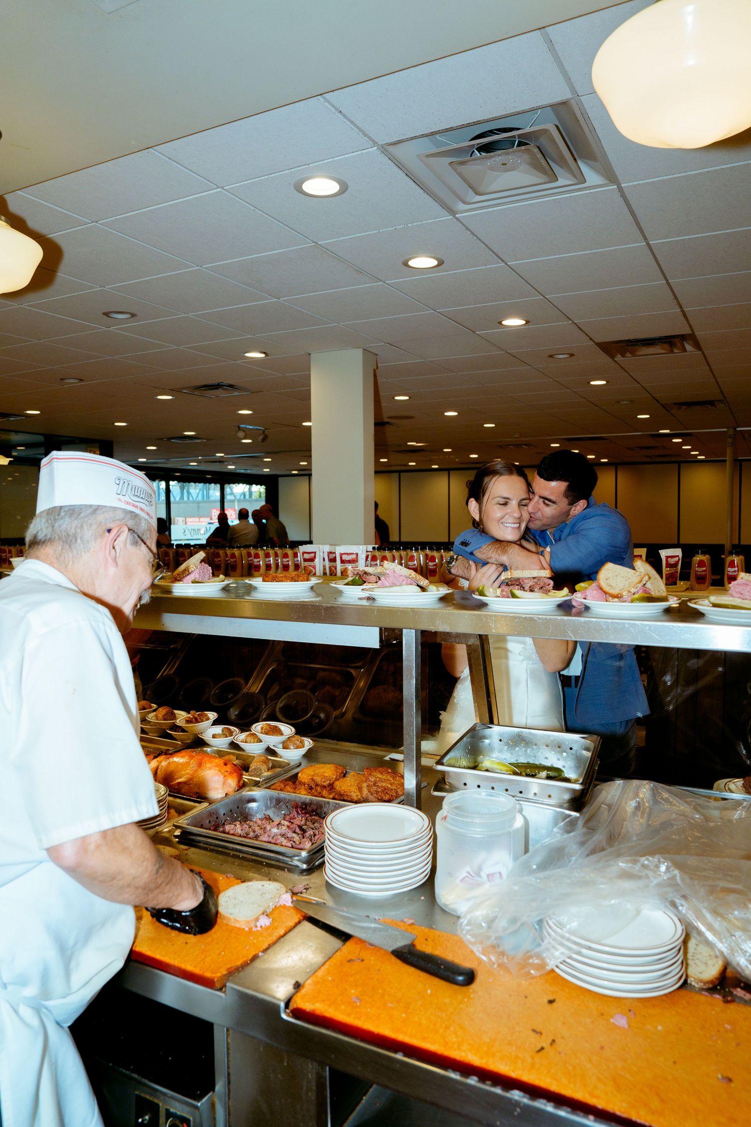 Kitchen staff preparing food behind a buffet counter in a restaurant setting.