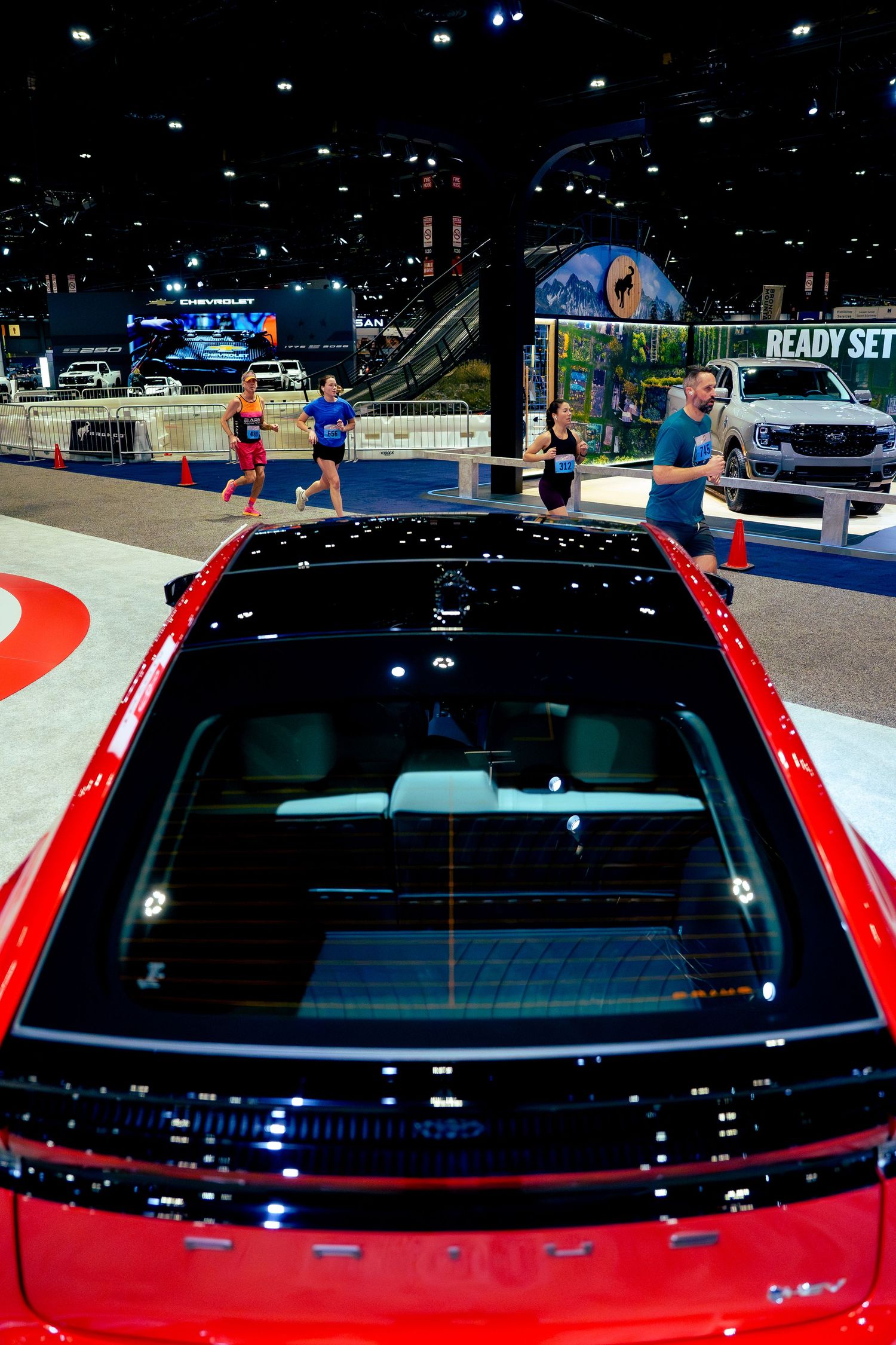 Close-up view of red car's windshield and roof at auto show display.