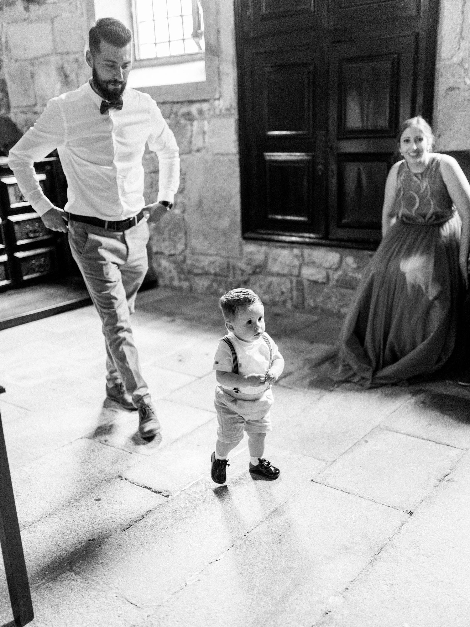 Black and white sequence of candid shots showing someone walking and dancing on a stone patio in casual attire.