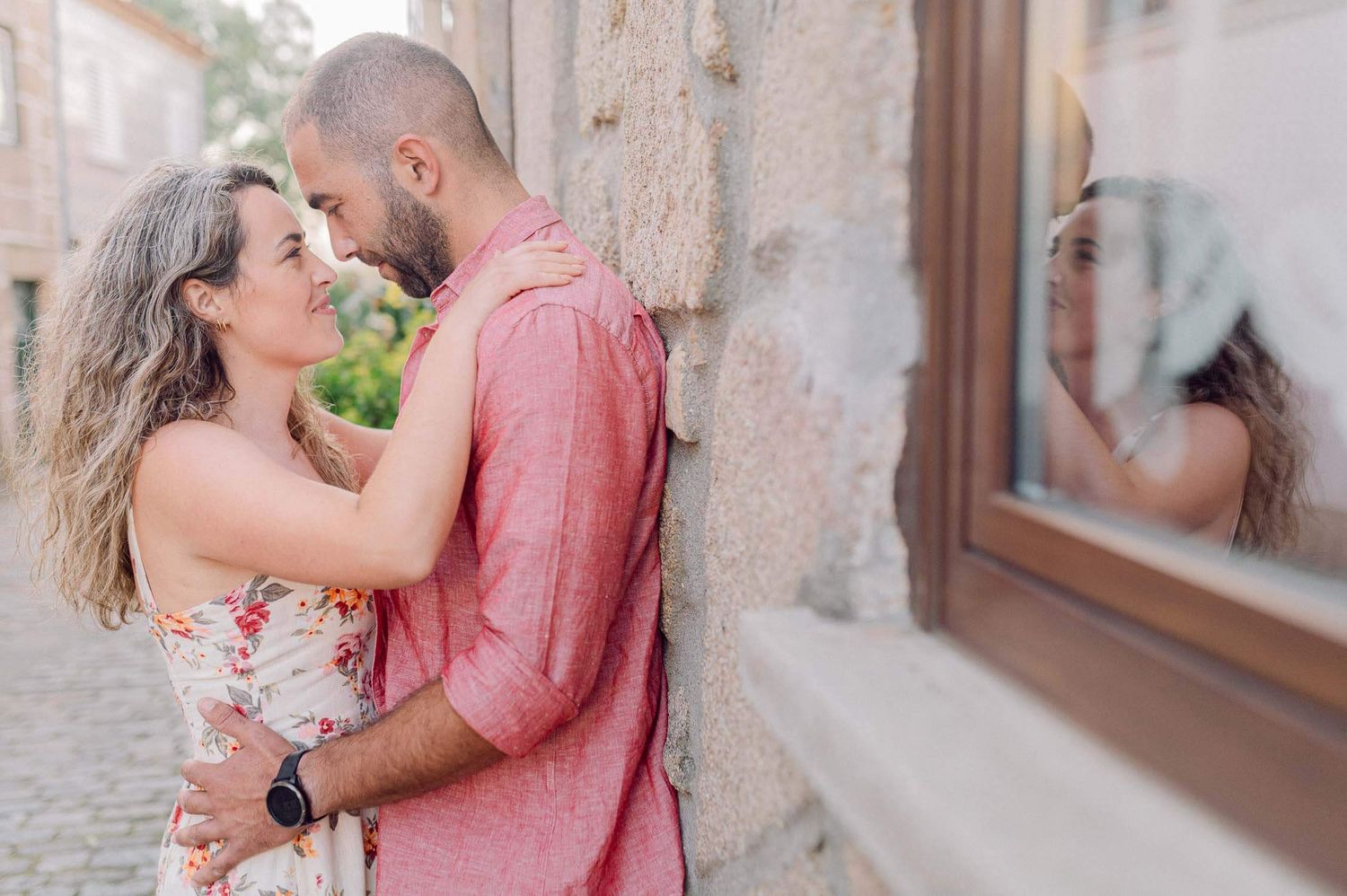 A couple shares romantic moments against stone walls in a series of engagement or wedding photos.