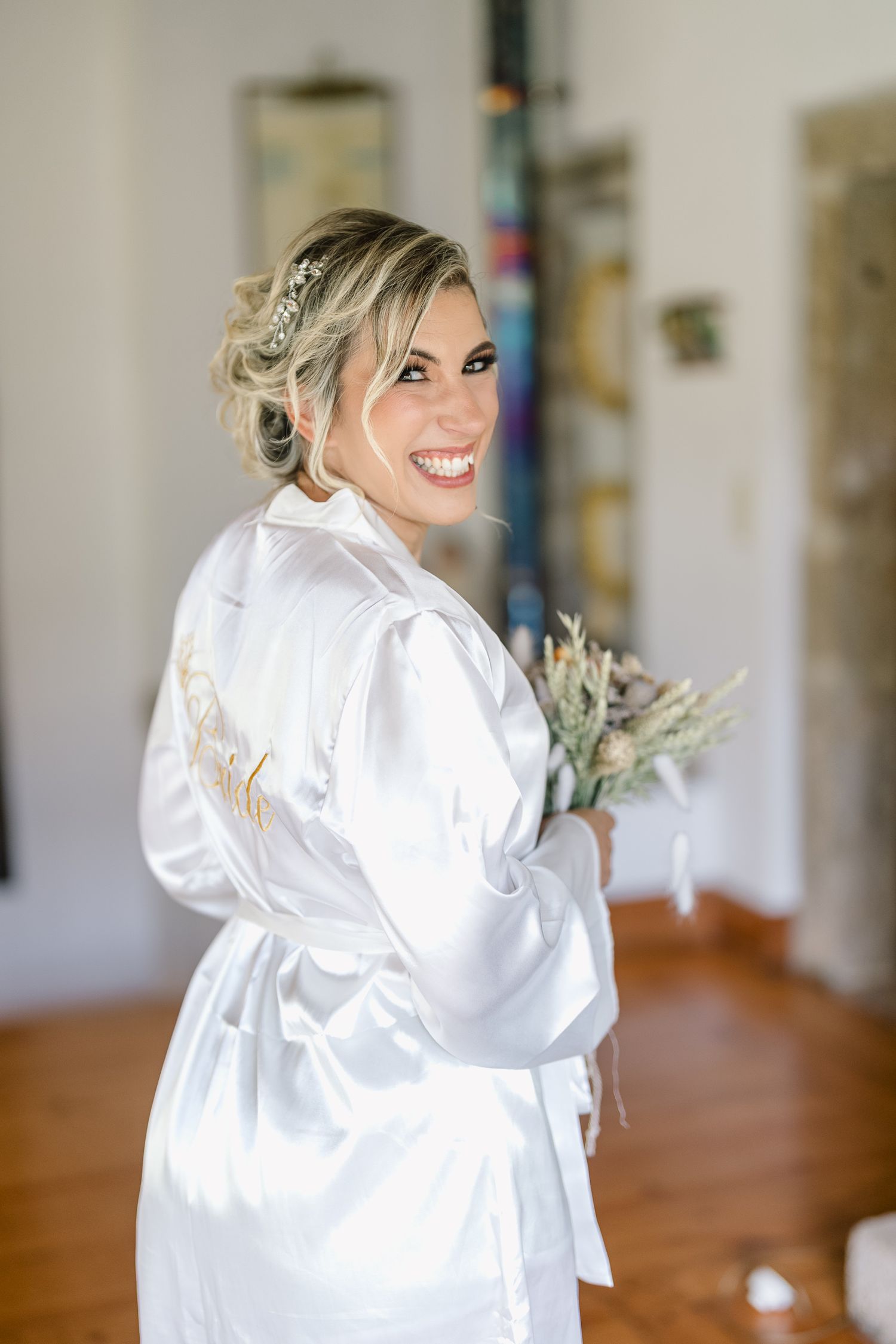 A person wearing a white satin robe smiles and poses in a series of candid getting-ready shots.
