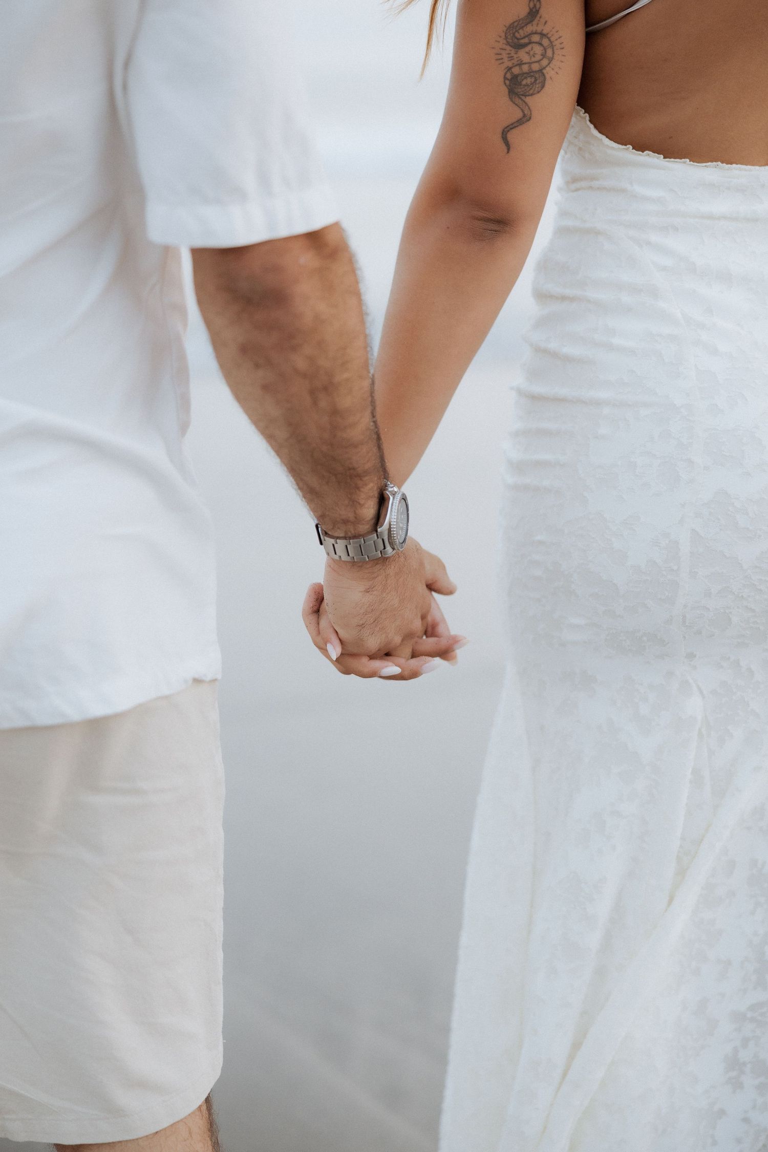 A series of white-clad figures showing close-up details of hands and arms with a DNA helix tattoo against a light background.