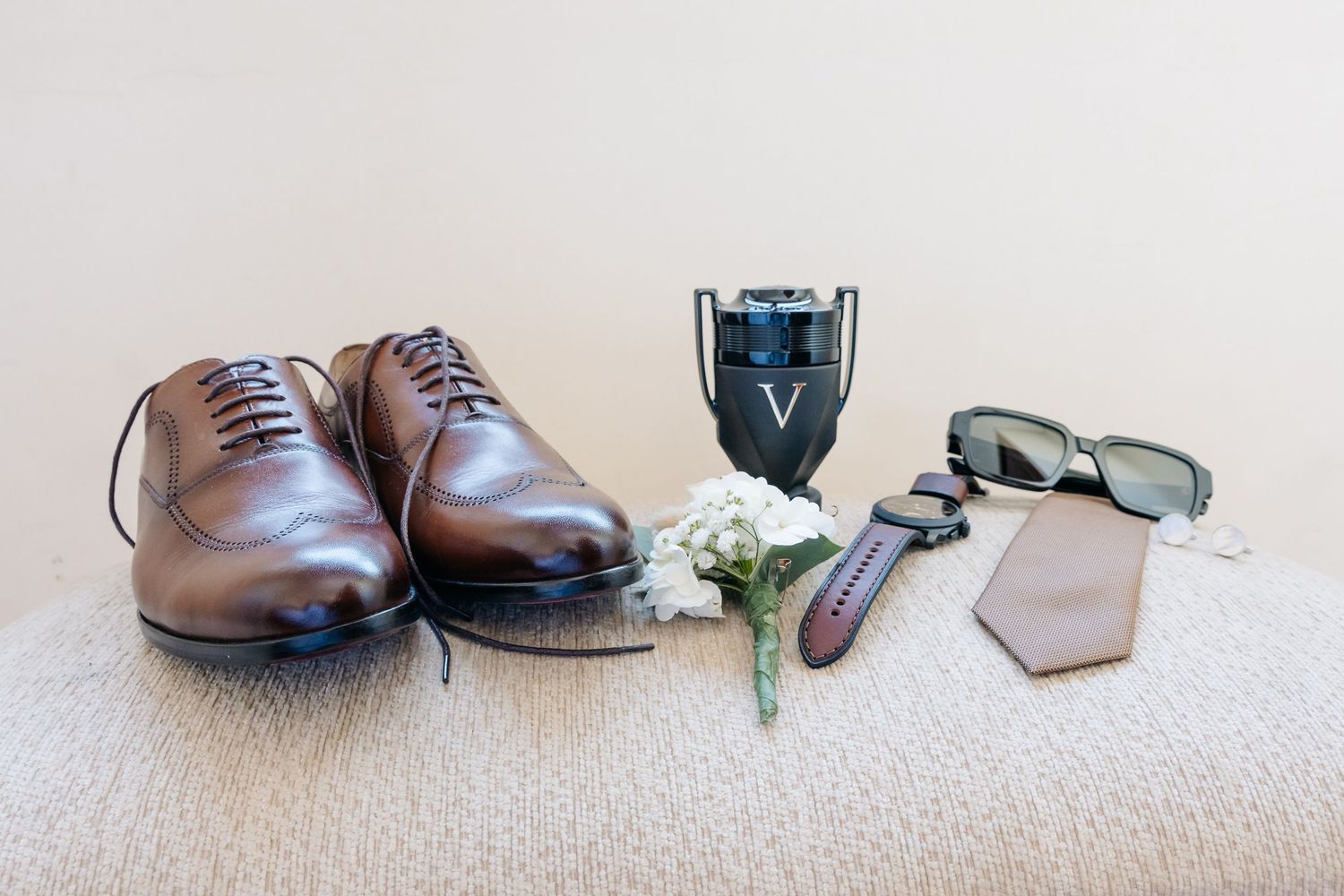 A row of brown leather dress shoes arranged in a line on a light carpet surface.