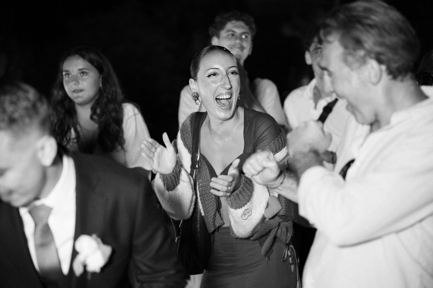 A black and white collage of candid photo booth style portraits showing people laughing and making expressions.