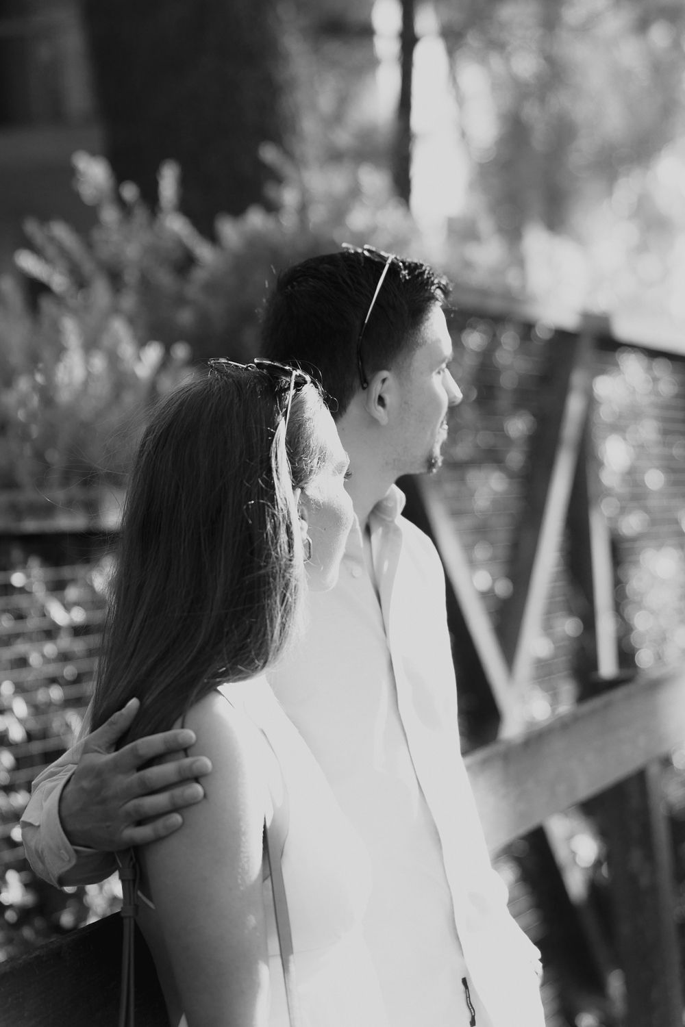 Retrato romântico em preto e branco de um casal em abraço íntimo ao ar livre.