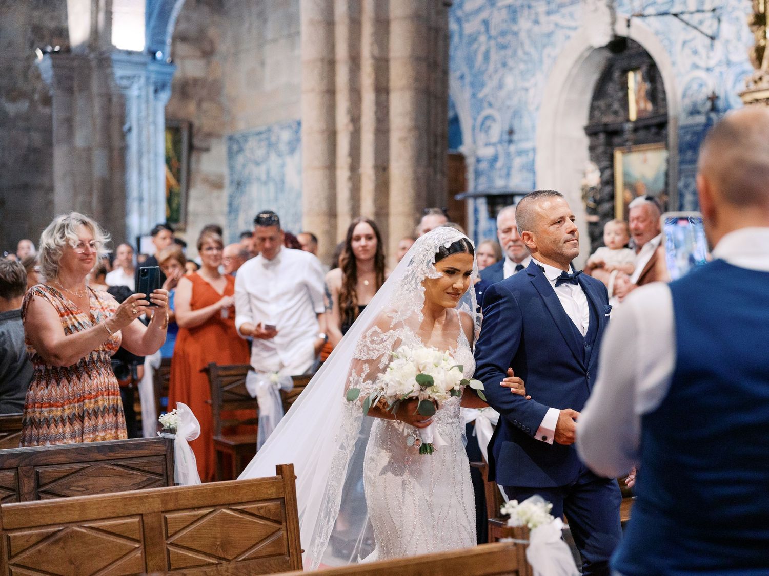A bride and groom celebrate with guests during a wedding ceremony in a historic church interior.