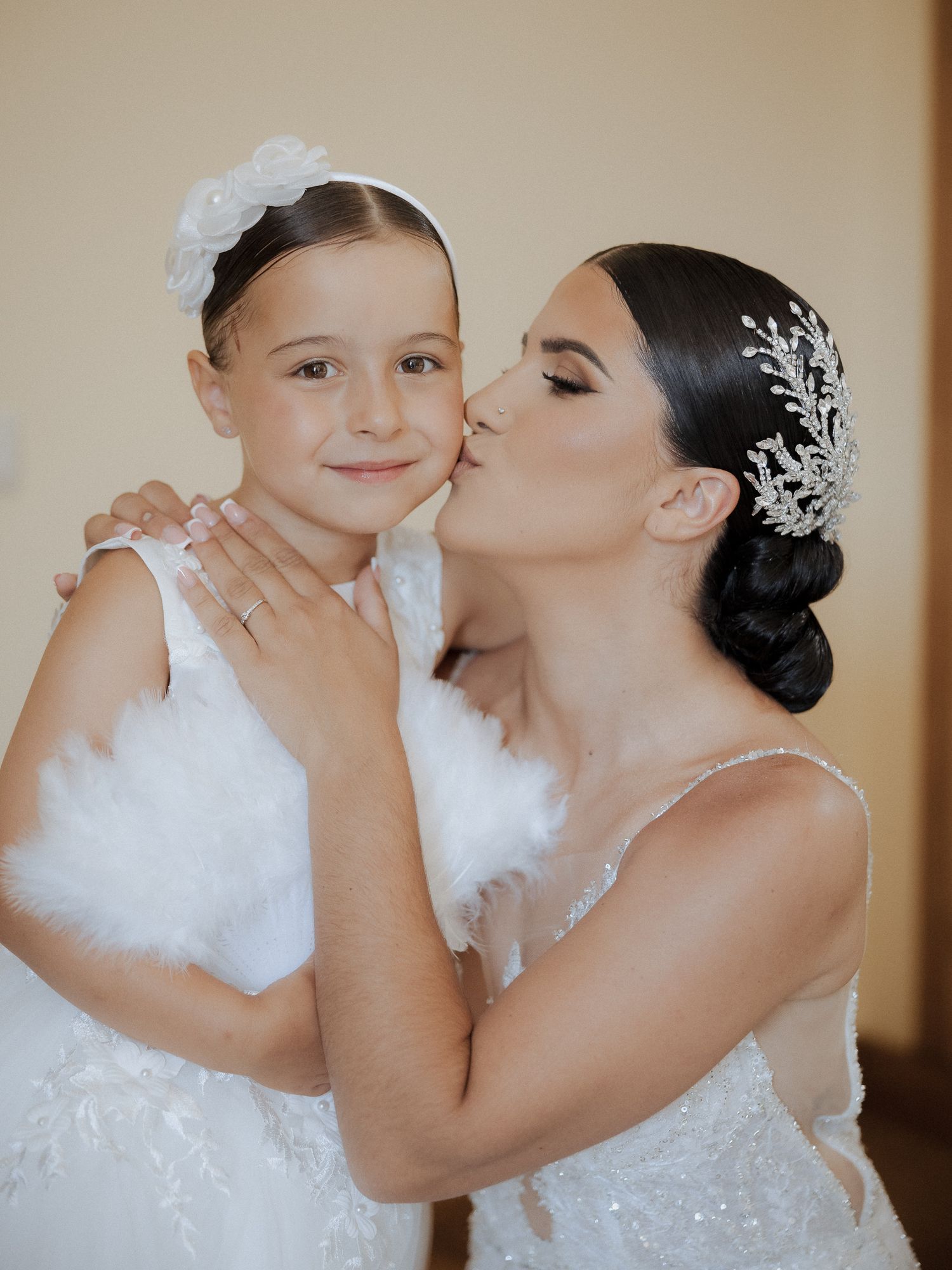 A tender moment captured in a series of wedding photos showing a bride and child sharing sweet kisses and embraces.