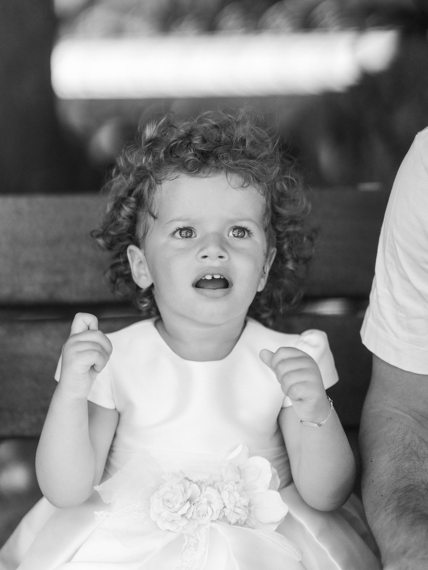 A sequence of black and white photos showing a baby making various playful facial expressions and hand gestures.