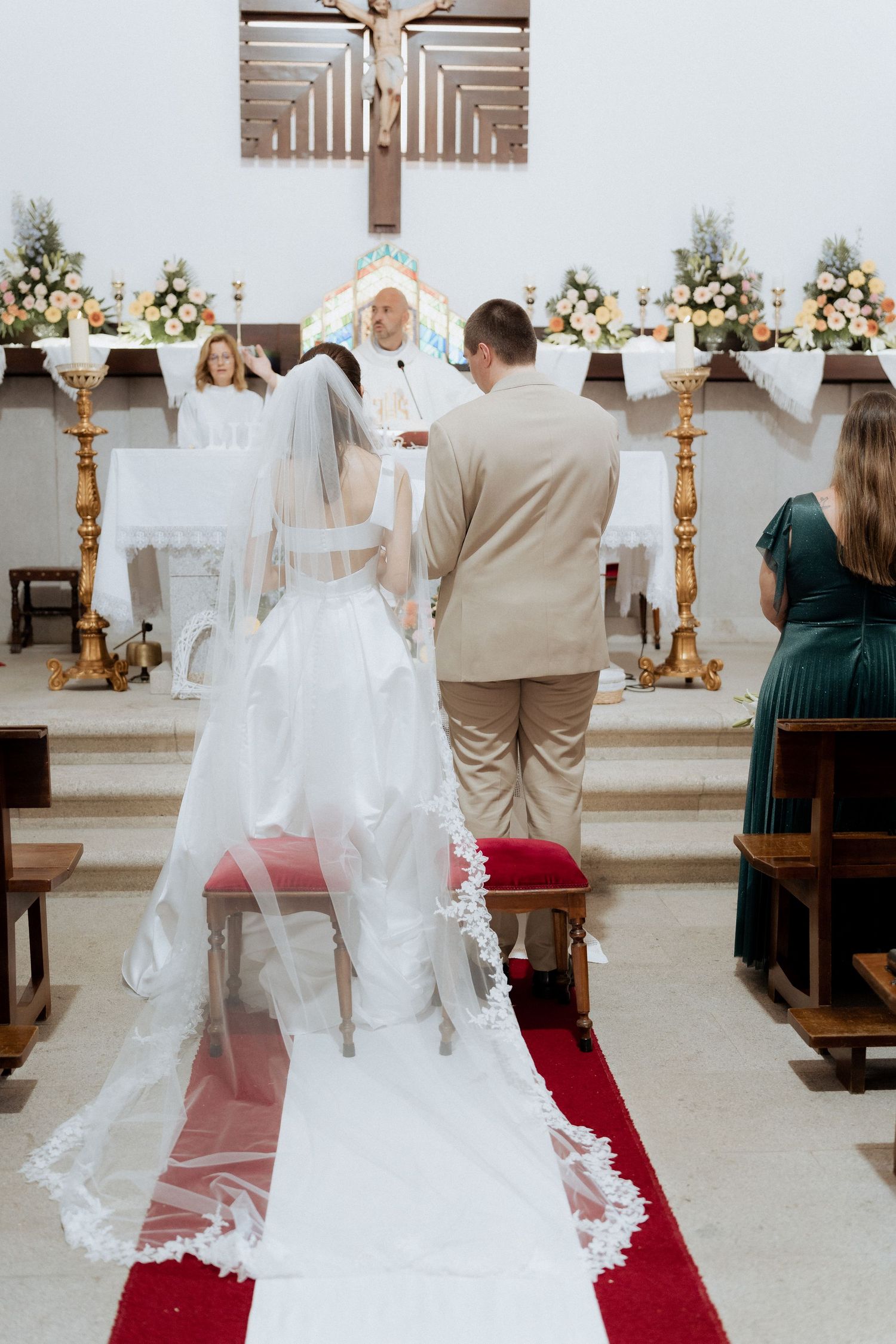 Cerimônia de casamento em uma igreja em Esposende com decoração branca e tapete vermelho no corredor.