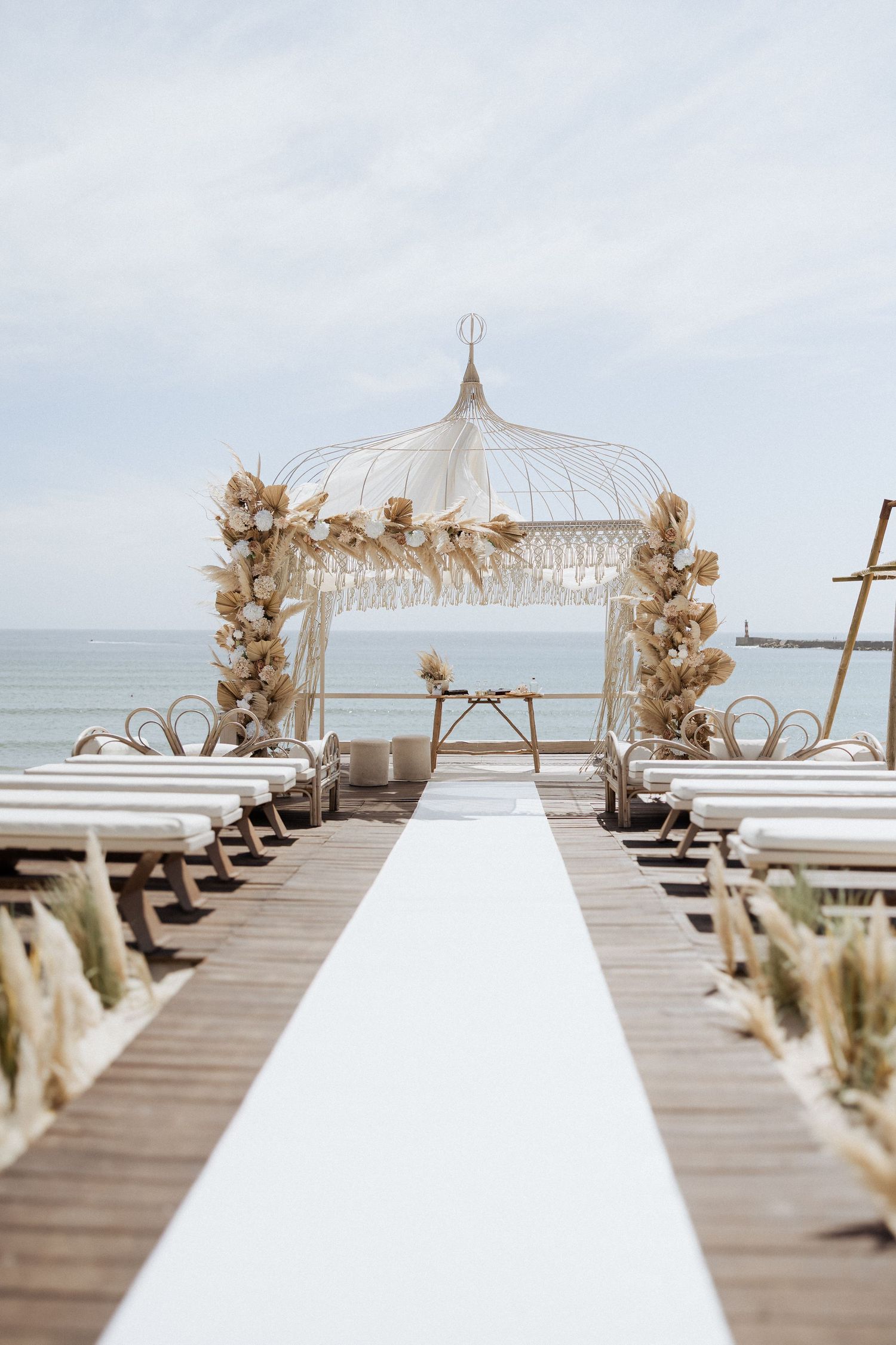 Elegante cerimônia de casamento à beira-mar com passadeira branca,  arco floral tendo o oceano como pano de fundo. SET LOUNGE- AZURARA