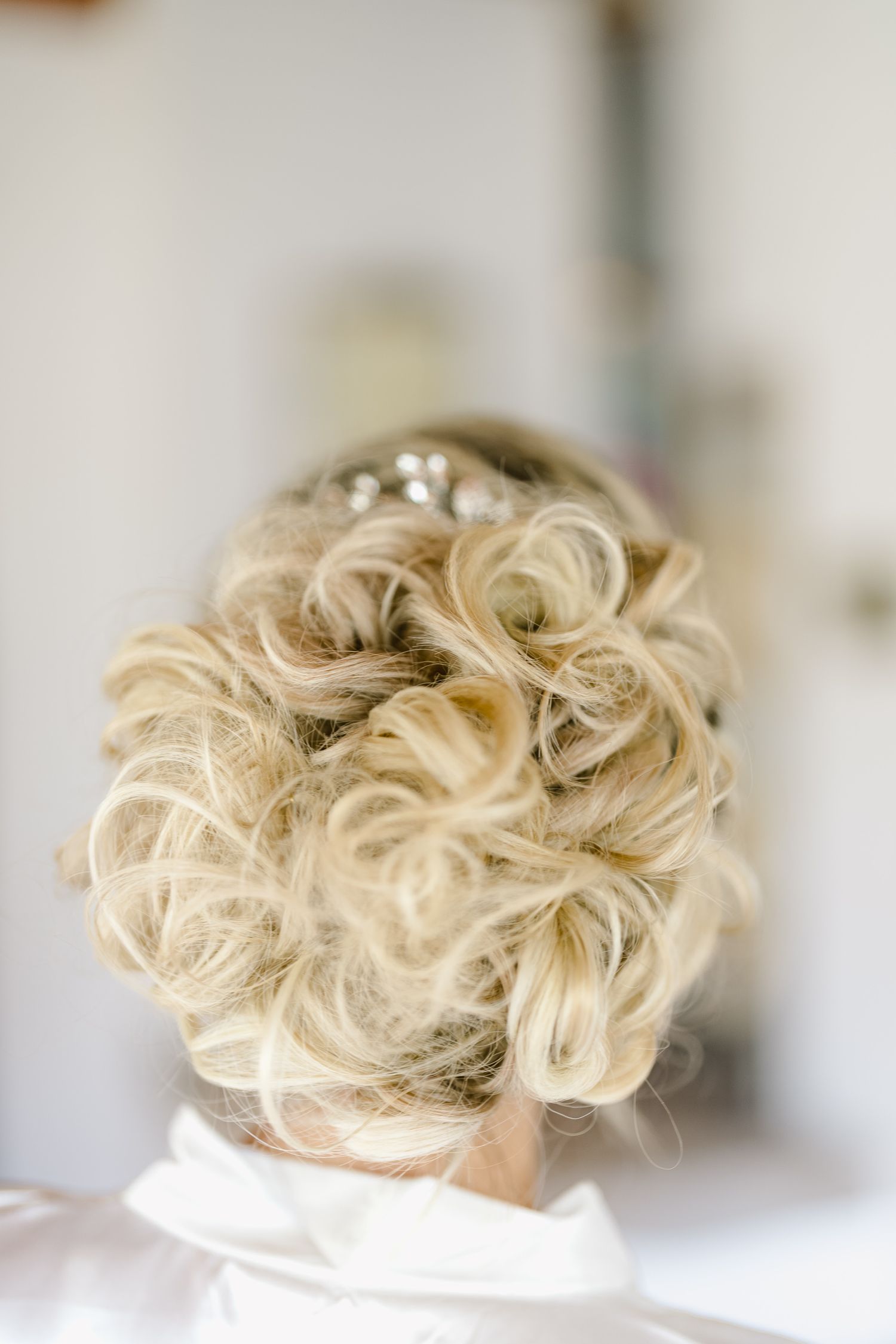 Elegant blonde updo hairstyle shown from multiple angles in a professional salon setting.
