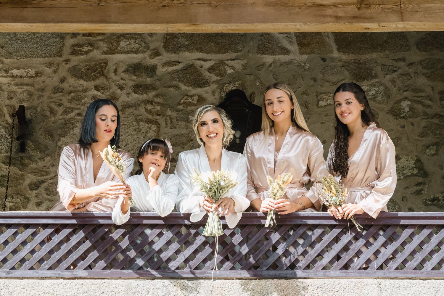 A group of people in matching silk robes sitting together on stone steps while laughing and having fun.