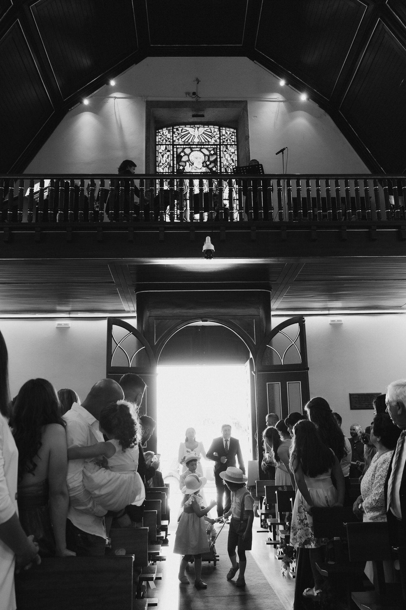 Black and white wedding reception photos showing guests dancing and celebrating in an elegant venue with balcony details.