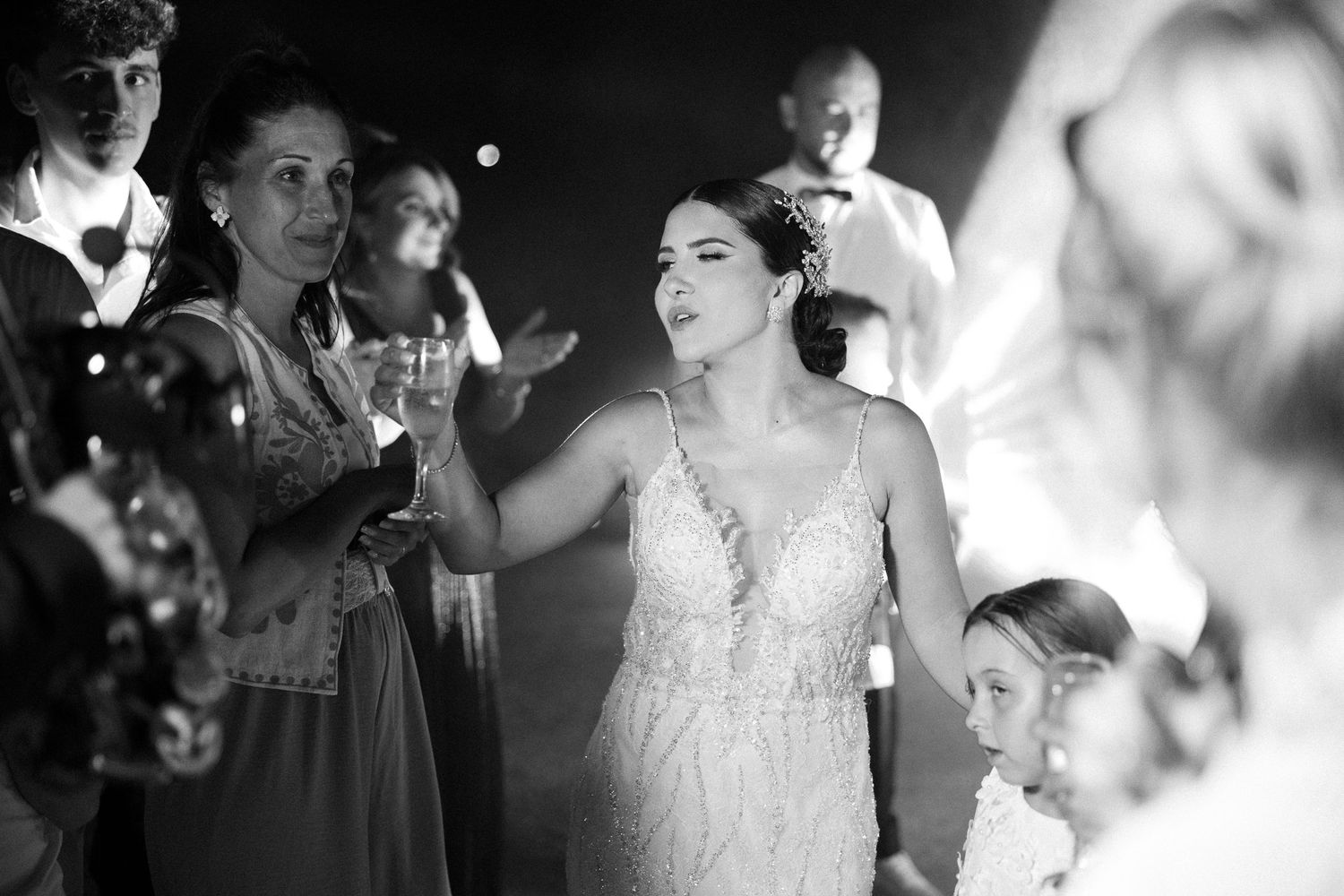 A black and white collage of candid wedding moments showing couples dancing and celebrating at a reception.