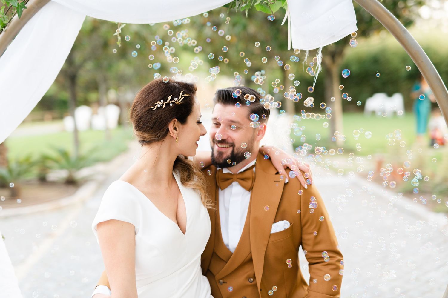 A couple shares a romantic moment outdoors while sparklers create magical light trails in the background.
