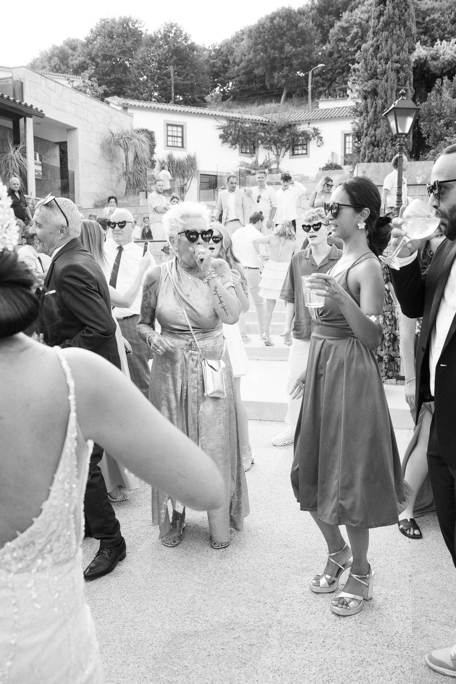 A black and white photo sequence shows people dancing in a line at an outdoor gathering.
