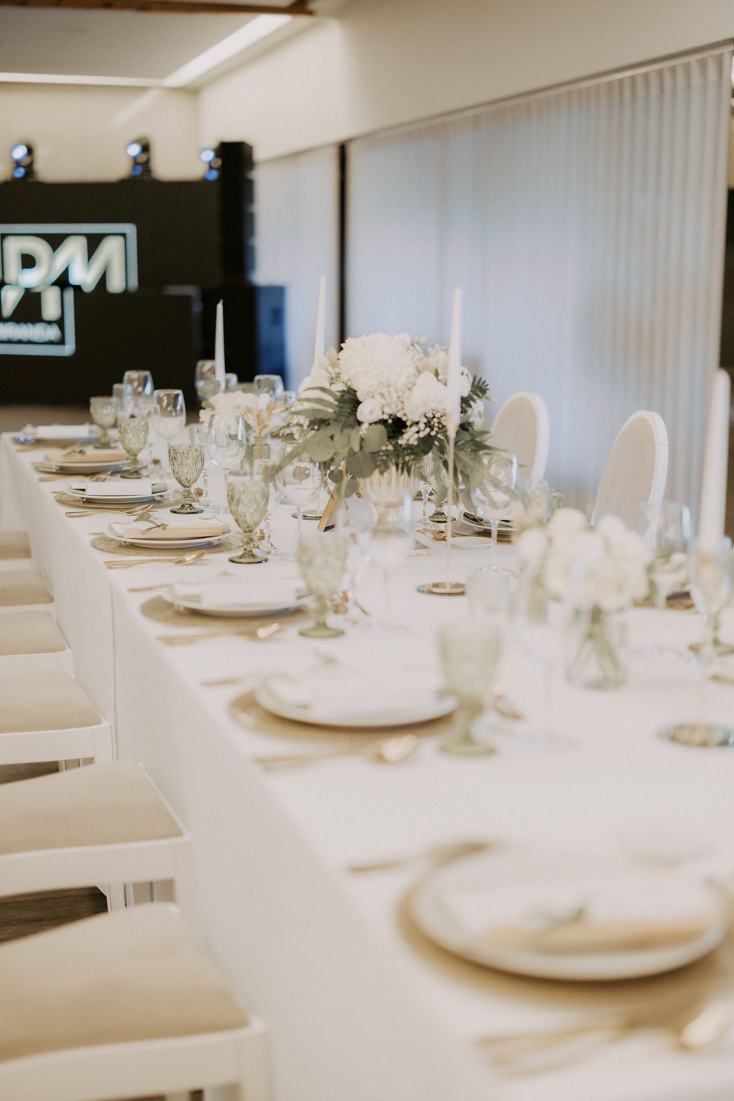 Elegant white table settings at a formal event with crisp linens and delicate place settings.