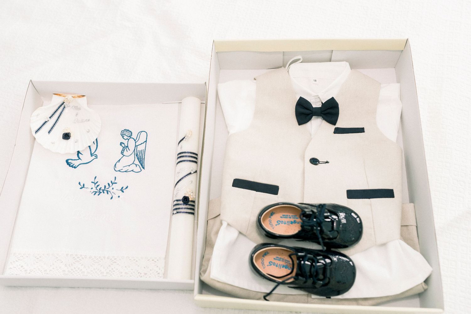 A series of baby items including a bow tie, shoes, and drawings arranged in a minimalist style on a white background.