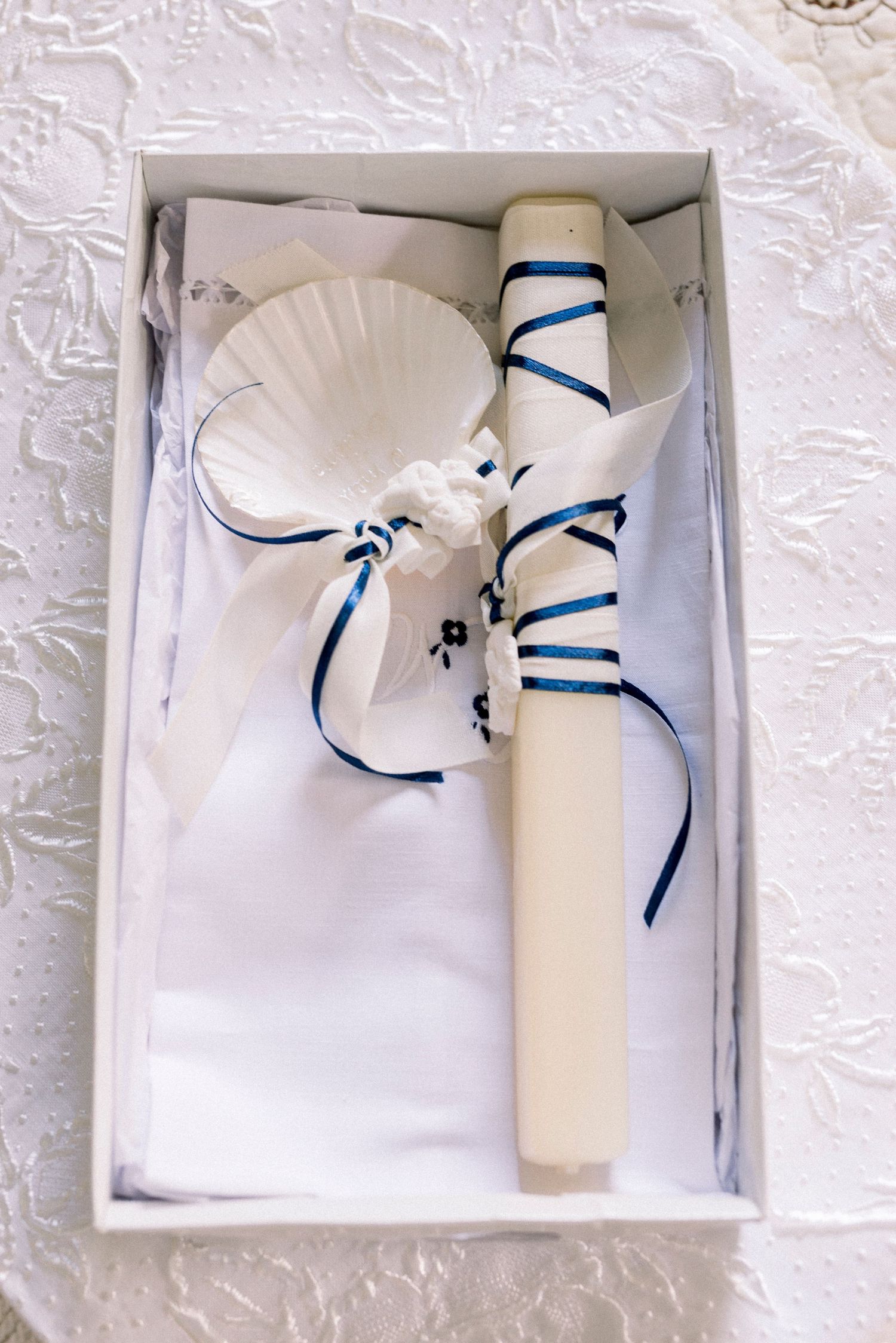 White wedding invitation box with elegant white and blue ribbon bow detail shown from multiple angles.